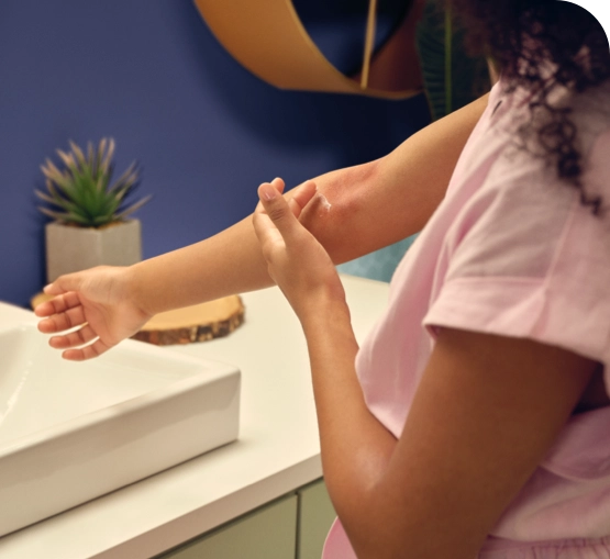  Photo of female applying OPZELURA to atopic dermatitis on the inside of her right elbow.
